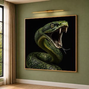 Op de afbeelding: Een vierkante muurkunstprint met een gedetailleerde, contrastrijke afbeelding van een groene slang met de bek wijd open, met scherpe giftanden en een gespleten tong. De slang staat tegen een zwarte achtergrond met een dunne gouden rand.
