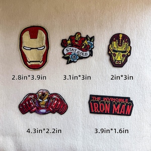 Op de afbeelding: Vijf geborduurde patches met Iron Man-ontwerpen. Eén helm (7,1cm*9,9cm), één figuur met bloemen en de tekst STAY GOLD (7,9cm*7,6cm), één gestileerde helm (5,1cm*7,6cm), één figuur met vuisten (10,9cm*5,6cm) en een rechthoekige patch met de tekst THE INVINCIBLE IRON MAN (9,9cm*4,1cm).
