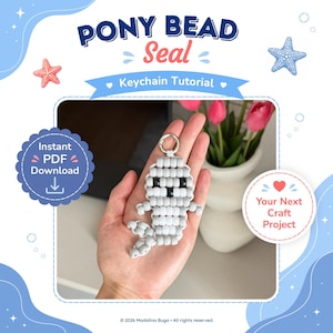 Puede incluir: Un tutorial de manualidades digital titulado PONY BEAD Seal Keychain Tutorial con descarga instantánea en PDF. La imagen muestra una figura de foca gris claro hecha de cuentas de plástico con ojos de cuenta negros y un llavero de metal.