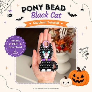 Könnte beinhalten: Ein schwarzer Katzen-Schlüsselanhänger aus Pony-Perlen mit türkisfarbenen Augen, einer rosa Nase und einem violetten Halsband. Das Design zeigt eine weiße Schnauze und weiße Pfoten. Der Text lautet PONY BEAD Black Cat Keychain Tutorial und Instant PDF Download.