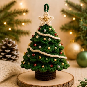 May include: A dark green crocheted Christmas tree ornament with a cream-colored star topper and a loop for hanging. The tree is decorated with small red, gold, and white beads, gold star accents, and a cream-colored crocheted garland wrapped around.