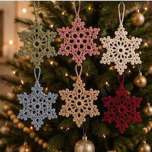May include: Six crocheted snowflake ornaments in sage green, dusty pink, cream, light blue, tan, and deep red. Each six-pointed star features intricate threadwork with a central circular opening and a matching loop at the top for hanging purposes.