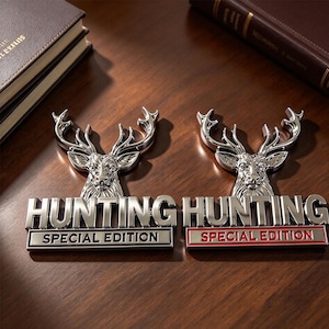 May include: Two metallic emblems featuring a detailed deer head silhouette above the text "HUNTING" and "SPECIAL EDITION". One emblem has black lettering on a silver base, while the other features red lettering on a silver base with a red border.