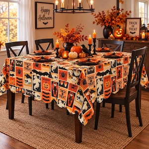 Könnte beinhalten: Eine quadratische Halloween-Tischdecke mit einem wiederkehrenden Muster aus Geistern, Kürbissen, Spinnen, Totenköpfen, Fledermäusen und dem Text Trick or Treat. Der orange, schwarze und weiße Stoff bedeckt einen Esstisch mit Tellern und Kerzen.