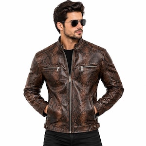 Peut inclure: Une veste marron avec un motif peau de serpent, un col montant à bouton-pression, une fermeture éclair centrale, deux poches poitrine zippées, deux poches latérales inférieures et des pattes de serrage à bouton-pression à la base.