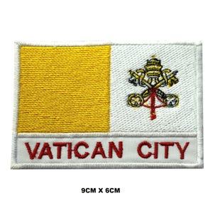May include: A rectangular embroidered patch featuring the Vatican City flag design with a yellow left section and a white right section containing the crossed keys and papal tiara emblem. The text VATICAN CITY is stitched in red at the bottom. 3.54 x 2.36 inches.