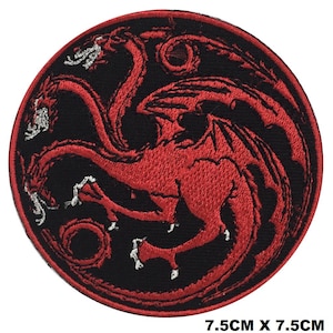 May include: A circular embroidered patch featuring a three-headed red dragon design on a black background with a red border. The dragon has intricate red stitching and white accents on its claws and heads. The patch measures 7.5 cm by 7.5 cm.