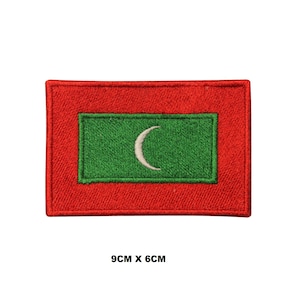May include: A rectangular embroidered patch featuring the flag of the Maldives, with a red border surrounding a green field containing a white crescent moon. The patch measures 9 cm by 6 cm as indicated by the text printed below the item.