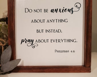 May include: A white wooden sign with a brown frame, featuring the text "DO NOT BE anxious ABOUT ANYTHING BUT INSTEAD, pray ABOUT EVERYTHING. PHILLIPIANS 4:6".