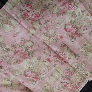 Pu&ograve; includere: Tessuto rosa con un motivo floreale con rose e tazze da t&egrave;. Il tessuto ha un bordo di pizzo bianco lungo il bordo inferiore.