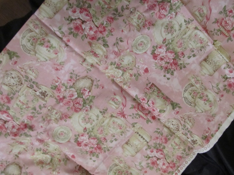 Pu&ograve; includere: Tessuto rosa con un motivo floreale con rose e tazze da t&egrave;. Il tessuto ha un bordo di pizzo bianco lungo il bordo inferiore.