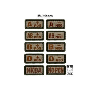May include: A collection of ten rectangular embroidered patches in a multicam pattern. Each patch features brown lettering indicating blood types A, AB, B, O, with positive or negative signs, plus NKDA and NO PCN labels. The text is clear and bold.