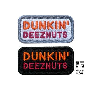 May include: Two rectangular embroidered patches with rounded corners. The top patch has a white background with orange text reading DUNKIN' and pink text reading DEEZNUTS. The bottom patch has a black background with the same orange and pink text.