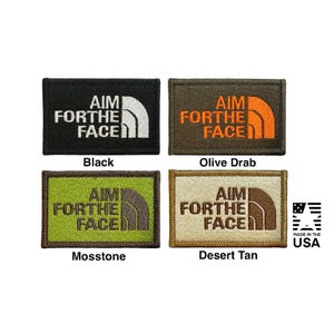 May include: Four rectangular embroidered patches featuring the text AIM FOR THE FACE and a curved line graphic. Colours include black with white, olive drab with orange, mosstone with dark brown, and desert tan with brown. Includes a MADE IN THE USA logo.