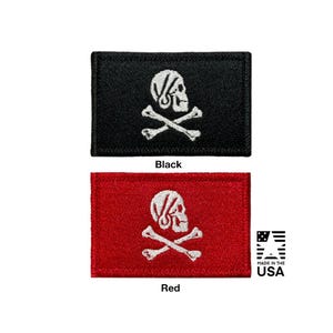 May include: Two rectangular embroidered patches featuring a white skull and crossbones design. One patch has a black background and the other has a red background. The skull is depicted in profile facing right. The text Black and Red appear below.