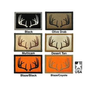 May include: Six rectangular embroidered patches featuring white or brown deer antler designs. Colors include black, olive drab, multicam, desert tan, blaze/black, and blaze/coyote. Each patch has a border and the text MADE IN THE USA is visible.
