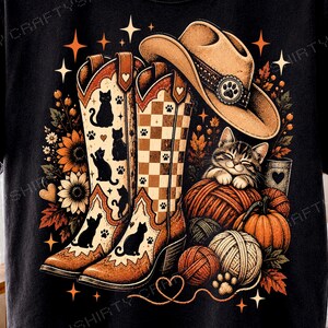 Könnte beinhalten: Ein schwarzes T-Shirt mit einer Grafik aus zwei Cowboystiefeln, einer mit Katzensilhouetten und einer mit Karomuster, einem beigen Cowboyhut mit Pfotenabdruck, einem Kätzchen auf Wollknäueln, Kürbissen, Sonnenblumen und Sternen.