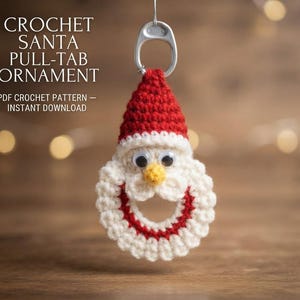 May include: A crochet Santa ornament featuring a red and white hat, a white beard, a yellow nose, and two plastic eyes, attached to a silver metal soda can pull-tab. The text CROCHET SANTA PULL-TAB ORNAMENT PDF CROCHET PATTERN INSTANT DOWNLOAD is visible.