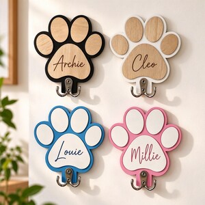 Può includere: Quattro ganci da parete a forma di zampa con basi in legno o colorate e cuscinetti bianchi o color legno. Ogni gancio mostra un nome in corsivo: Archie, Cleo, Louie e Millie. I ganci sono realizzati in metallo argentato con due punte.