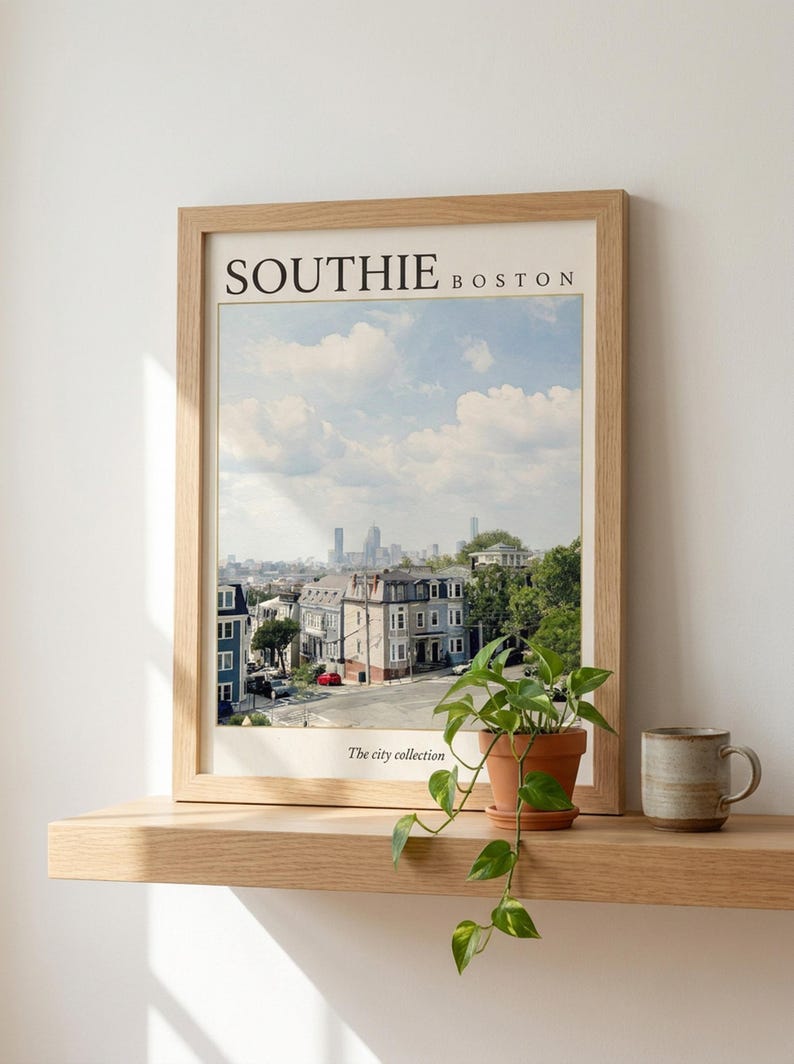 May include: A framed wall art print titled SOUTHIE BOSTON with the text The city collection at the bottom. The print features a daytime cityscape view of Boston with residential buildings in the foreground and a skyline under a blue sky with clouds.