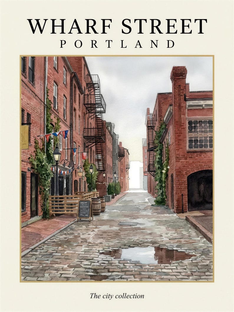 May include: A watercolor print titled WHARF STREET PORTLAND The city collection, depicting a cobblestone street lined with red brick buildings, black metal fire escapes, green climbing vines, street lamps, and a small menu board.