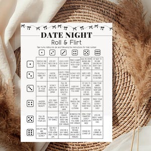 May include: A white rectangular game card titled DATE NIGHT Roll & Flirt with a black bow border. The grid features dice icons and text instructions for romantic activities, including prompts like kiss my neck and trace a heart on my back.