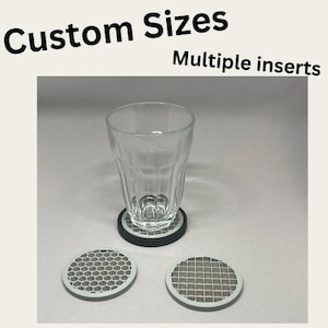 May include: A clear glass tumbler sits on a circular coaster with a black rim and a gray honeycomb pattern. Two additional circular coasters are placed in front, one with a honeycomb pattern and one with a grid pattern. Text reads Custom Sizes.