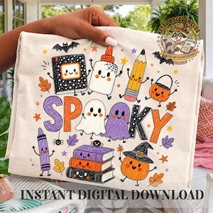 Puede incluir: Una camiseta color crema con un estampado gráfico colorido con el texto SPOOKY. El diseño incluye ilustraciones estilo dibujos animados de un cuaderno, un bote de pegamento, un lápiz, un cubo de calabaza, un crayón, libros apilados y una calabaza.