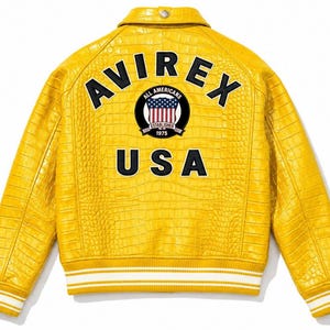 May include: A bright yellow jacket with a textured crocodile-skin pattern. The back features the black text AVIREX and USA, along with a circular patch displaying the American flag and the text All Americans Established 1975. It has white striped cuffs.