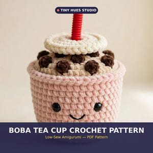 Może przedstawiać: Szydełkowy amigurumi w kształcie kubka herbaty boba z jasnoróżowym kubkiem z uśmiechniętą buzią, beżową pokrywką, ciemnobrązowymi perełkami boba i czerwoną słomką. Widoczny jest tekst TINY HUES STUDIO oraz BOBA TEA CUP CROCHET PATTERN.