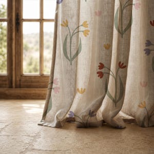 May include: A beige linen-textured curtain panel featuring a repeating pattern of stylized flowers in shades of yellow, red, purple, and pink with sage green stems and leaves. The fabric has a visible weave and hangs in soft, vertical folds.