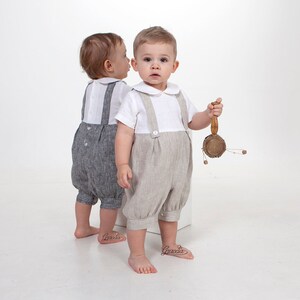 Puede incluir: Dos ni&ntilde;os peque&ntilde;os con camisas blancas de manga corta con cuello redondo y petos de estilo lino. Un peto es de color gris oscuro y el otro es de color beige claro. Los petos cuentan con tirantes abotonados y un dise&ntilde;o frontal plisado.