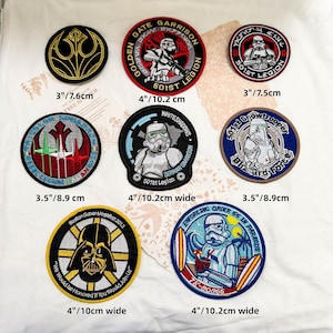 May include: Eight circular embroidered patches featuring Star Wars themes, including a Rebel Alliance symbol, various Stormtrooper designs, a Snowtrooper, and Darth Vader. Sizes range from 3 inches to 4 inches wide as labeled on the white fabric.