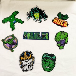 Puede incluir: Una colección de ocho parches bordados con personajes de cómic. El conjunto incluye varias representaciones de Hulk, She-Hulk, Thanos, un parche rectangular con el texto THE INCREDIBLE HULK y otro con la palabra HULK.