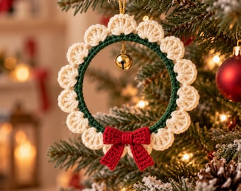 May include: A circular crochet ornament featuring a dark green inner ring bordered by cream-coloured scalloped edges. A small gold jingle bell hangs from the top centre, and a red crocheted bow is attached to the bottom of the wreath.