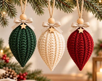 May include: Three teardrop-shaped crochet ornaments in dark green, cream, and deep red. Each ornament features a natural wooden bead, a beige fabric bow, and a small wooden star accent, suspended by a jute twine loop for hanging.