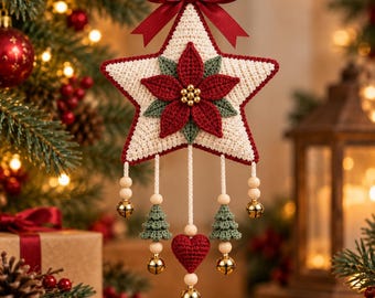 May include: A star-shaped crochet ornament in cream with a red poinsettia centre, topped with a red satin bow. It features hanging strands with wooden beads, small green crochet trees, a red crochet heart, and gold jingle bells.
