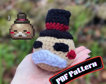 Puede incluir: Un juguete de peluche tejido a ganchillo de color beige, con un sombrero de copa negro con una banda roja, ojos negros, un bigote blanco y detalles rojos en las mejillas. La imagen incluye el texto AbiesCustomDesigns y PDF Pattern.