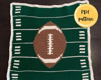 Puede incluir: Una manta de ganchillo cuadrada para bebé con un diseño de campo de fútbol americano verde, líneas blancas y un balón marrón central con cordones blancos. El texto Football Baby Blanket y PDF pattern aparecen claramente en la imagen.