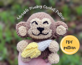 Puede incluir: Un juguete de mono tejido a ganchillo en marrón y beige que sostiene un plátano tejido en amarillo y blanco. El texto Adorable Monkey Crochet Pattern está sobre el mono y un círculo amarillo con el texto PDF pattern está a la derecha.