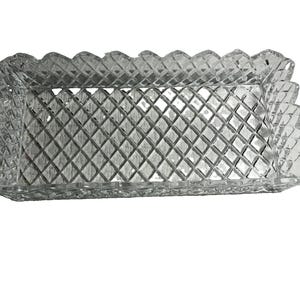 May include: A rectangular clear glass tray featuring a prominent diamond-cut lattice pattern across its entire surface. The edges of the tray are scalloped and serrated, creating a textured, faceted appearance that reflects light throughout the piece.