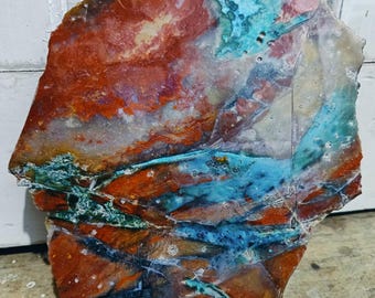 Ruwe natuurstenen plaat in kleurrijke rode en blauwe tinten, geschikt voor geologische doeleinden.