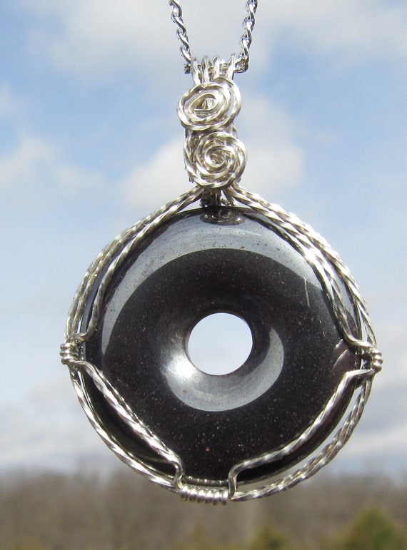 A Polished Hemalyke Donut Wire Wrapped Pendant in Argentium Silver