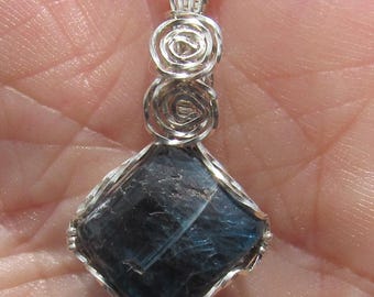 Pendentif enroulé de cyanite bleue polie dans un fil d'argent sterling.