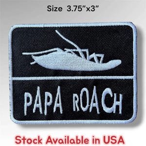 May include: A rectangular black embroidered patch featuring a white graphic of a cockroach above the white text "PAPA ROACH". The patch has a white border and measures 3.75 inches by 3 inches as indicated by the text above the item.