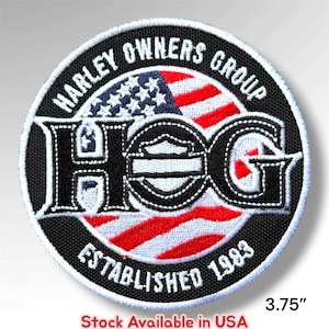 May include: A circular embroidered patch featuring the text HARLEY OWNERS GROUP and ESTABLISHED 1983 in white on a black border. The center displays a stylized American flag background with the large black letters HOG and a shield emblem. 3.75 inches.