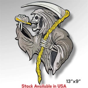 May include: An embroidered patch featuring a skeleton figure in a grey hooded robe holding a yellow scythe and drinking from a yellow glass. The patch measures 13 inches by 9 inches and includes the text Stock Available in USA at the bottom.
