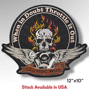 May include: A black embroidered patch measuring 12 inches by 10 inches featuring a central skull surrounded by yellow and red flames. Below the skull are silver wings and a brown banner with the text Go HOG Wild. The text When in Doubt Throttle it Out curves along the top border.