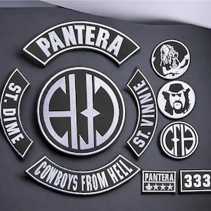May include: A collection of black and white embroidered patches featuring the band Pantera. Includes curved rocker patches with text reading PANTERA, ST. DIME, ST. VINNIE, and COWBOYS FROM HELL, a large circular logo patch, and smaller circular and rectangular patches.
