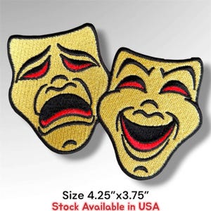 May include: Two embroidered patches featuring theater masks in gold thread with black outlines and red accents. One mask displays a sad expression, while the other shows a happy expression. The patches measure 4.25 inches by 3.75 inches.